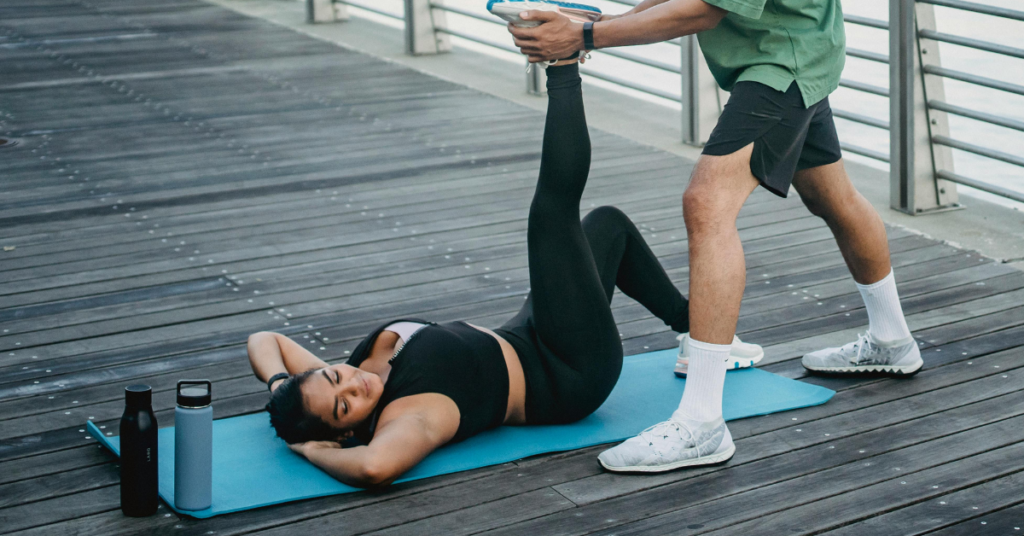 Gentle Workouts for Knee Pain, walking, stretching on a boardwalk with assisted leg stretches on a yoga mat.